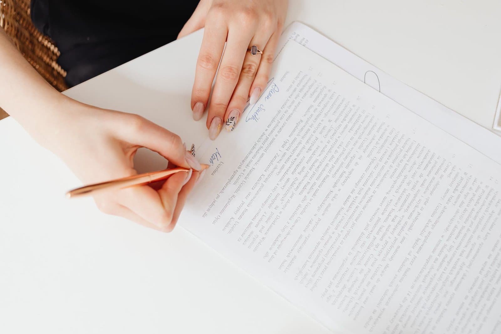 person writing on white paper Property Management Agreement