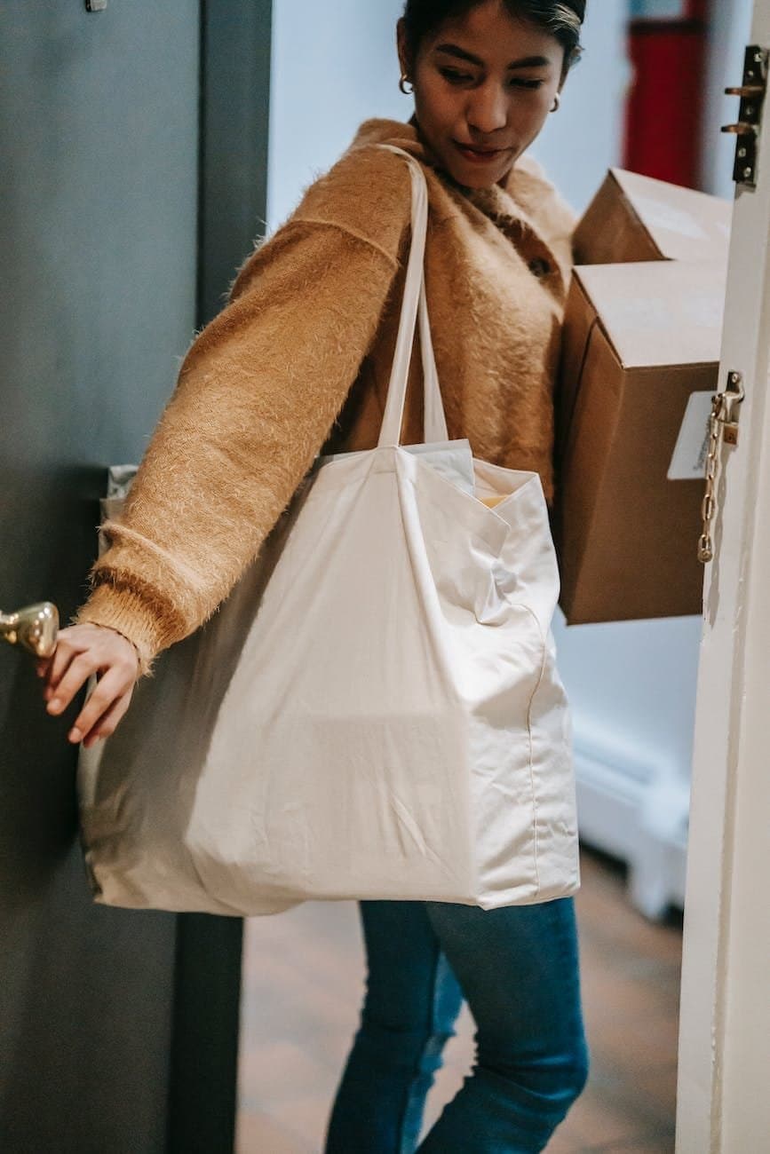 indian female with shopping bags leaving apartment