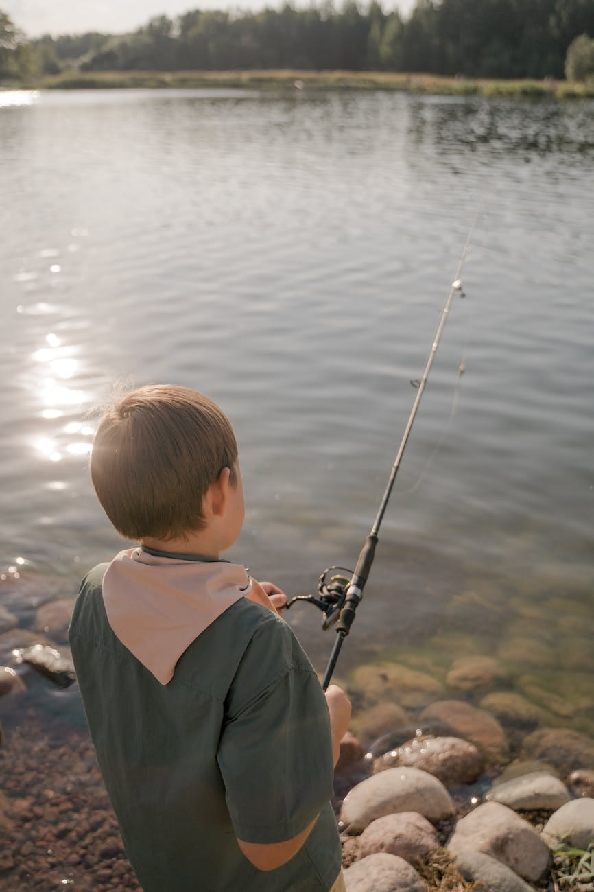 back view of a boy fishing at the lake in northdale property management