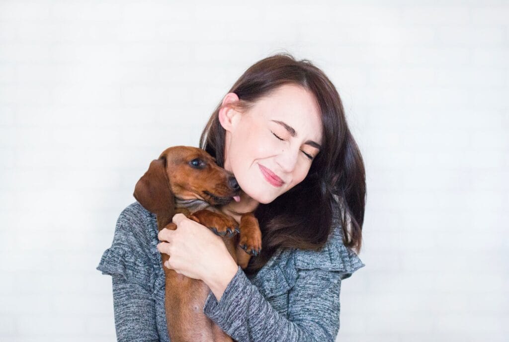 allow pets woman in grey top hugging brown dachshund